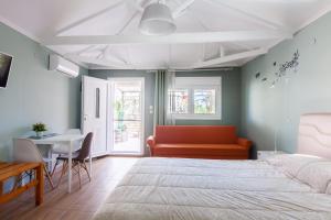 a bedroom with a bed and a couch and a table at Garden Rooms in Fanari