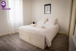 a white bed with white sheets and pillows on it at Loc'Nuit - Appartements Tout Confort - Hyper Centre AGEN in Agen