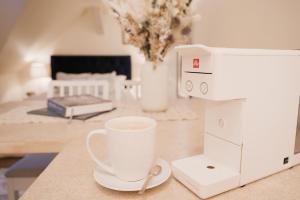 a cup of coffee sitting on a counter next to a sewing machine at Karlamuiza Country Hotel in Kārļi