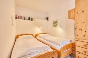 two beds in a small room with bookshelves at Haus Pavillon, App 20 in Döse