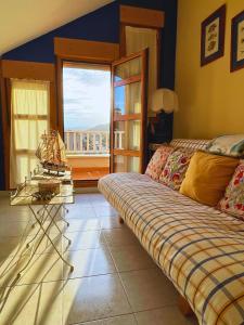 sala de estar con sofá y ventana en Apartamentos Melgarden - El Balcón de los Lirios, en Argoños