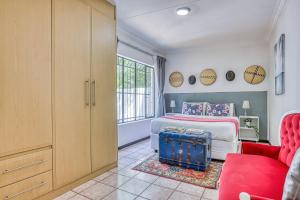 ein Schlafzimmer mit einem Bett und einer roten Couch in der Unterkunft The Cottage-1 Bed-pool-bbq-fibre-solar-samrand in Centurion + 20 Fotos