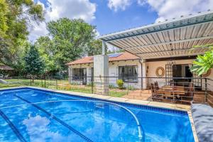a swimming pool with a pergola and a house at The Cottage-1 Bed-pool-bbq-fibre-solar-samrand in Centurion