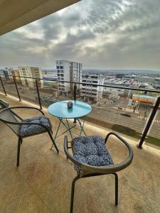 d'une table et de chaises sur un balcon avec vue sur la ville. dans l'établissement Fancy Apartament Promenada Mall, à Craiova