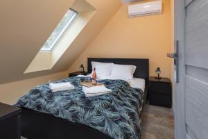 Un dormitorio con una cama con dos toallas encima. en Dom OSTOYA Wrzosowo - Ogród, Plac Zabaw & Klimatyzacja by Noclegi Renters, en Radawka