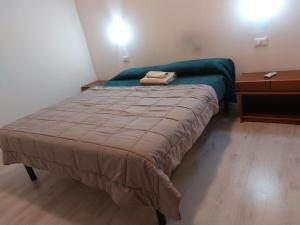 um pequeno quarto com uma cama e uma mesa de cabeceira em Carpe Diem em Treviso