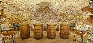 a group of barrels in a room with a stone wall at Legado de Ugarte, Casa Rural in Laguardia
