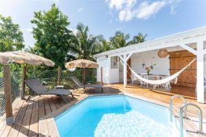 a pool with a hammock and a house at "Le Pavillon" - Résidence Blue Palm - St François - Guadeloupe in Saint-François