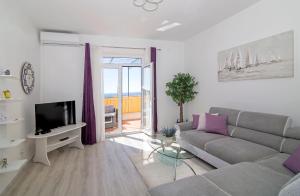 een woonkamer met een bank en een televisie bij Apartments Isabora in Dubrovnik
