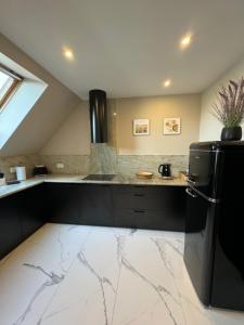 a kitchen with a black refrigerator and a counter at Apartamenty Beauty & SPA in Ełk