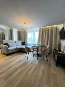 a living room with a couch and a table at Apartamenty Beauty & SPA in Ełk