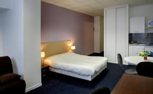 En eller flere senge i et værelse på KOSY Appart'Hôtels - Le Cours Moreau