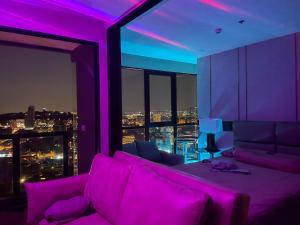 芭達雅南區的住宿－THE PANORA PATTAYA，紫色的客厅配有沙发和窗户