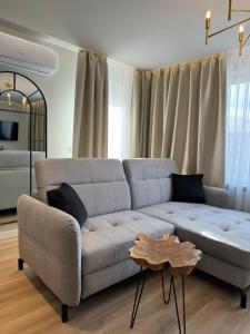 a living room with a white couch and a table at Apartamenty Beauty & SPA in Ełk