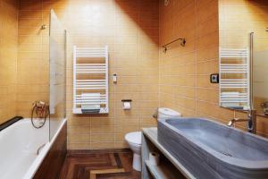 a bathroom with a tub and a toilet and a sink at Can Ricart in Puigcerdà