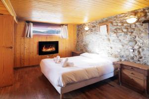a bedroom with a bed and a stone wall at Can Ricart in Puigcerdà