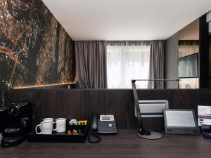 een bureau met een telefoon en een printer bij Heeton Concept Hotel – Luma Hammersmith in Londen