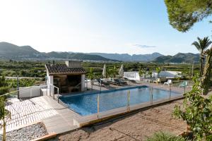 a villa with a swimming pool and mountains in the background at Finca de l’Anglès. Casa Mistral in Potríes