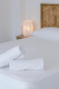 a white bed with two white towels on it at Finca de l’Anglès. Casa Mistral in Potríes