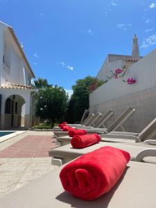 a row of red pillows are lined up next to a building at Villa Lucia, Olhos D'Agua, Albufeira in Albufeira