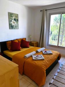 1 Schlafzimmer mit 2 Betten, Handtüchern und einem Fenster in der Unterkunft Suis Le Soleil in Brézilhac