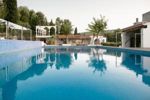 a large swimming pool with blue water at Finca de l’Anglès. Casa Mistral in Potríes
