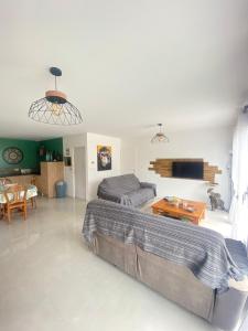 ein Wohnzimmer mit einem Bett und einem Sofa in der Unterkunft maison au calme in La Tourlandry