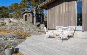 a group of chairs and a table on a deck at Lovely Home In Helgeroa With Harbor View in Helgeroa