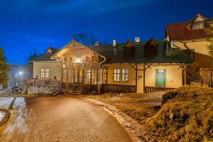 una casa con una puerta verde por la noche en Soví Dom - Owl House, en Svätý Anton