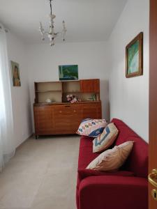 a living room with a red couch and a dresser at Tra i Parchi in Pescina