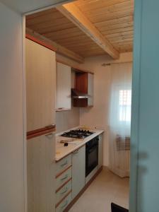 a kitchen with white cabinets and a stove top oven at Tra i Parchi in Pescina