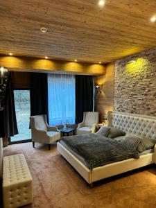 een slaapkamer met een groot bed en 2 stoelen bij Wolfstein - Le Boutique Hotel in Bad Harzburg
