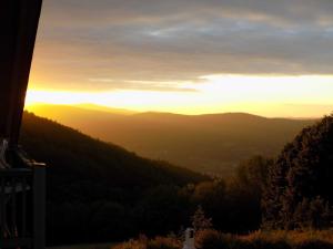 a sunset in the mountains with the sun setting at Ferienland Sonnenwald Fewo 46 in Langfurth 