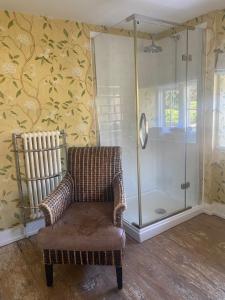 a bathroom with a chair and a shower at The Seagrave Arms in Weston Subedge