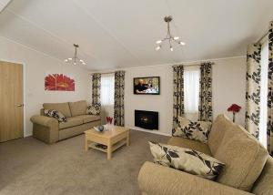 a living room with two couches and a fireplace at The Woods in Tillicoultry