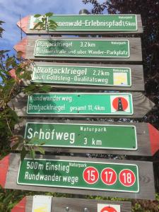 Ein Haufen Straßenschilder an einer Stange in der Unterkunft Ferienland Sonnenwald Studio 50 in Langfurth 