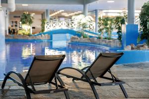 duas cadeiras sentadas em frente a uma piscina em Quality Hotel Skjærgården em Langesund