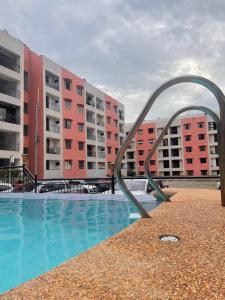 a metal sculpture next to a swimming pool with buildings at The Family Suite at the Mactan Airport in Pusok