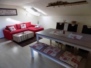 een woonkamer met een rode bank en een tafel bij Ferienwohnung Hauzenberg Blick FeWo306 in Hauzenberg