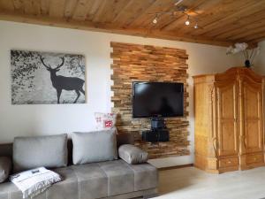 ハウツェンベルクにあるFerienwohnung Hauzenberg Blick FeWo306のレンガの壁にリビングルーム(ソファ、テレビ付) +50枚の写真