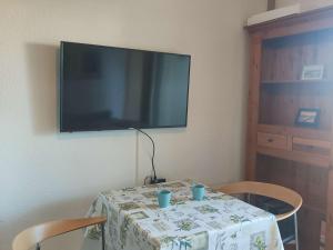 einen Tisch mit 2 Stühlen und einen TV an der Wand in der Unterkunft Appartement Port Barcarès, 2 pièces, 4 personnes - FR-1-195-4 in Le Barcarès