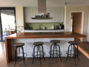 una cocina con una barra con 4 taburetes en Luxury Lakeside Villa en Katrineholm