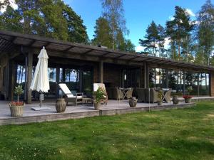 pawilon z parasolem i krzesłami oraz trawnikiem w obiekcie Luxury Lakeside Villa w mieście Katrineholm
