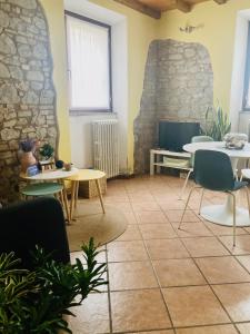 Pokój ze stołami i krzesłami oraz kamienną ścianą w obiekcie Residenza Borgo 9 w mieście Collecchio