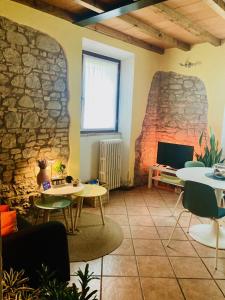a room with tables and a stone wall at Residenza Borgo 9 in Collecchio