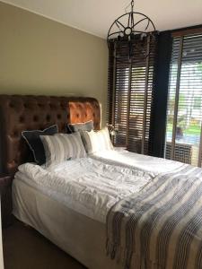 1 dormitorio con 1 cama grande y cabecero de madera en Luxury Lakeside Villa en Katrineholm