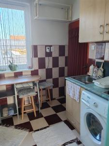 a kitchen with a sink and a washing machine at Skylark Relax Apartman in Szeged