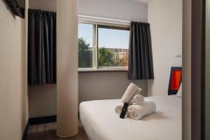 a bedroom with a bed with two towels on it at easyHotel Milton Keynes in Milton Keynes