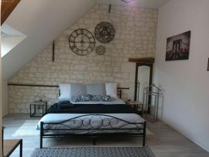 a bedroom with a bed and a wall with clocks at A 2 pas d AZAY in Neuil