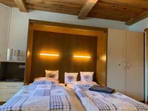a bedroom with two beds and a wooden headboard at Ferienwohnung Waldblick FEWO 502 in Freudensee